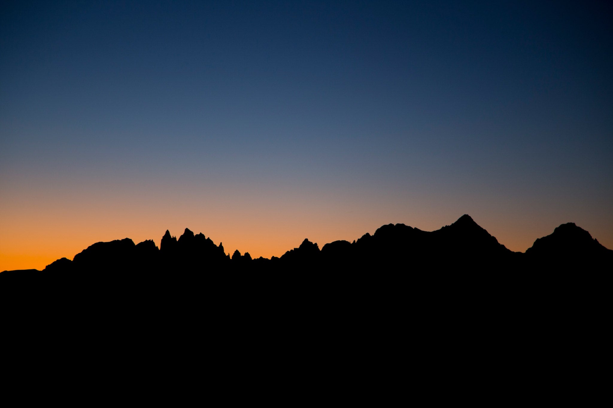 sunset silhouettes the Mammoth Lakes skyline - the Minarets, Ritter, and Banner