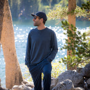 A man smiles wearing sunglasses and the Ridge Natural Tencel Crew Sweatshirt by a lake in Mammoth