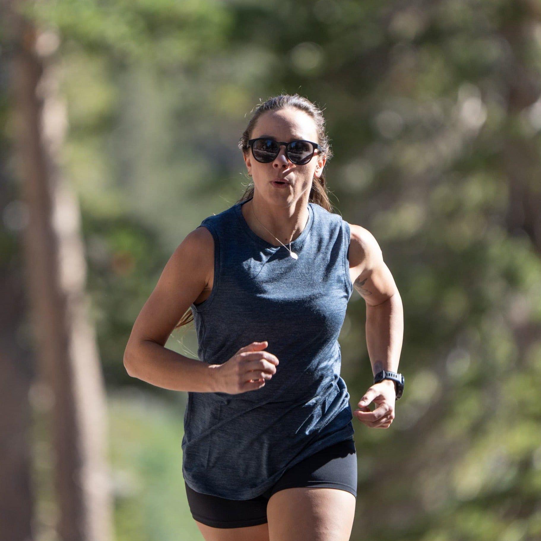 a woman running in a a woman hiking wearing a Natural Tencel Merino Tank