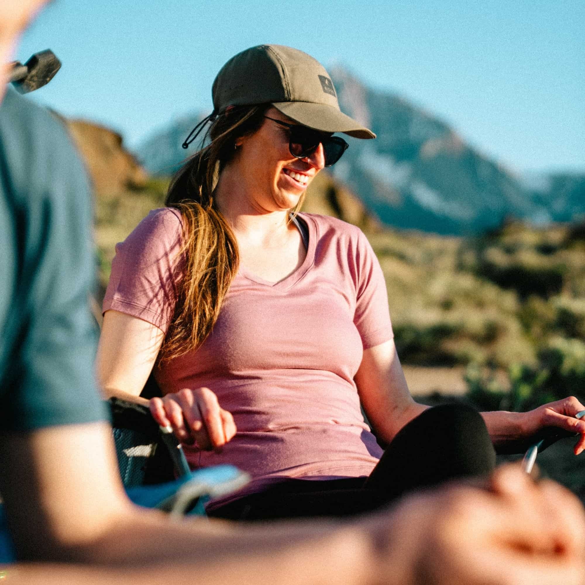 a woman camping wearing a Wander V-Neck T-shirt in Wild Rose