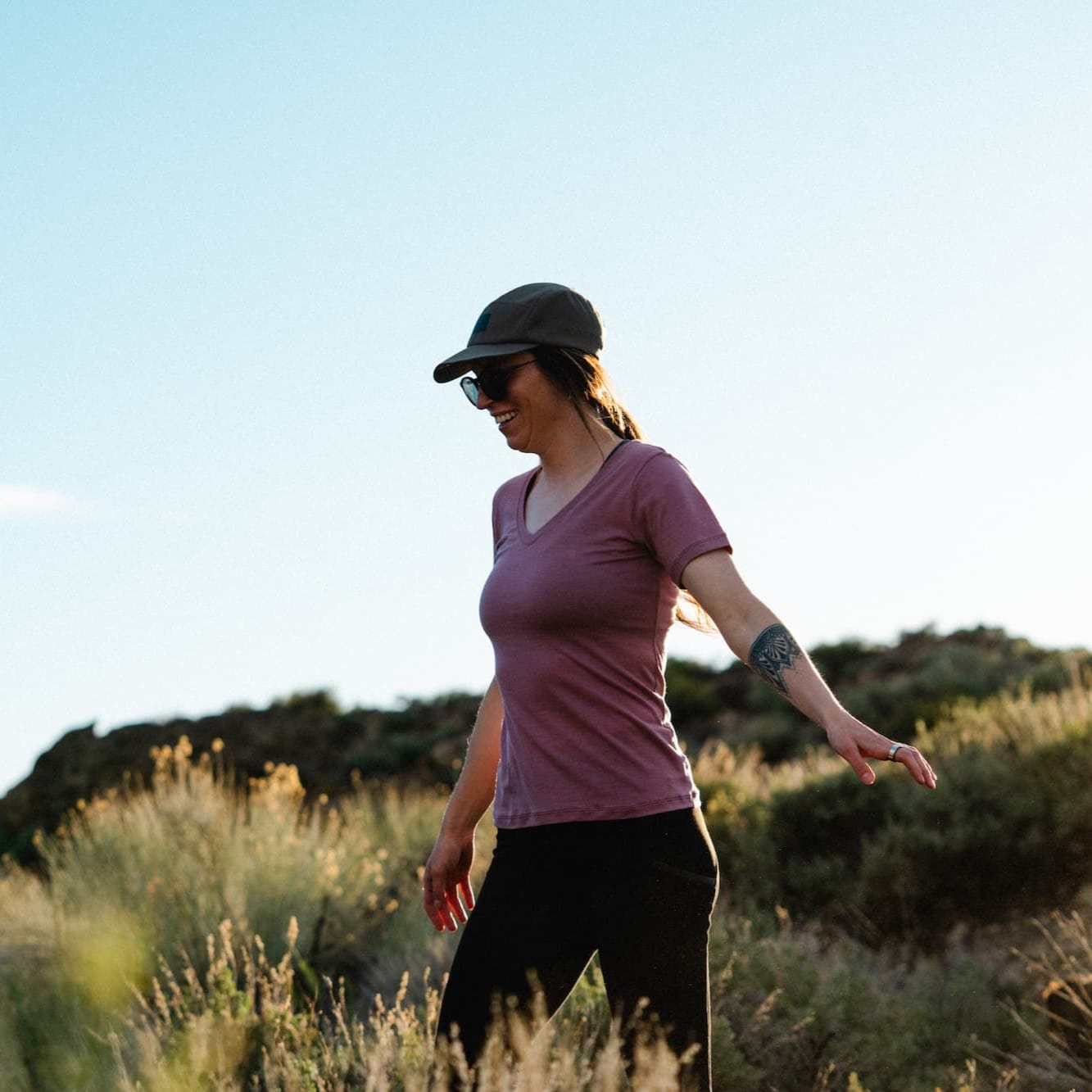 a woman hiking wearing a Wander V-Neck Tee in Wild Rose