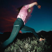 a woman jumping in Crowley Tights and a Wander V-Neck Tee