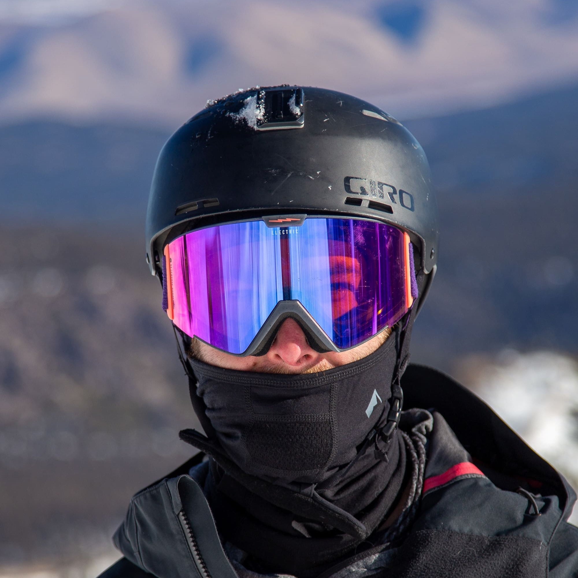 a skier wearing ski goggles, a helmet and a black Merino Wool Balaclava