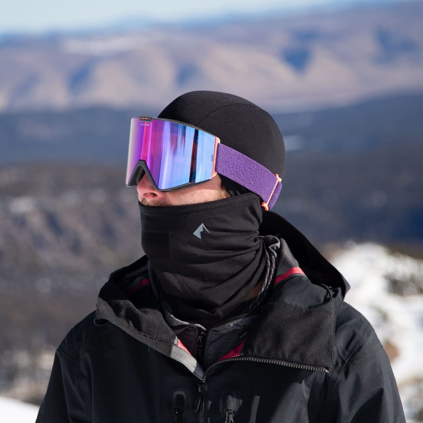 a skier wearing ski goggles and a black Merino Wool Balaclava