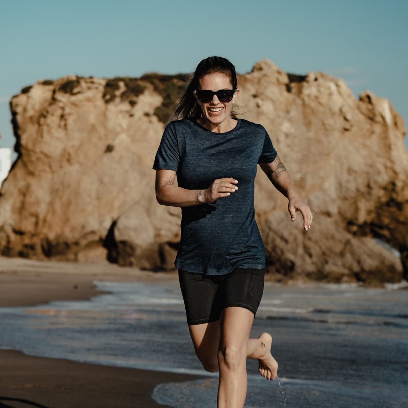 a woman running on the beach in Pursuit tee and Hilltop Shorts
