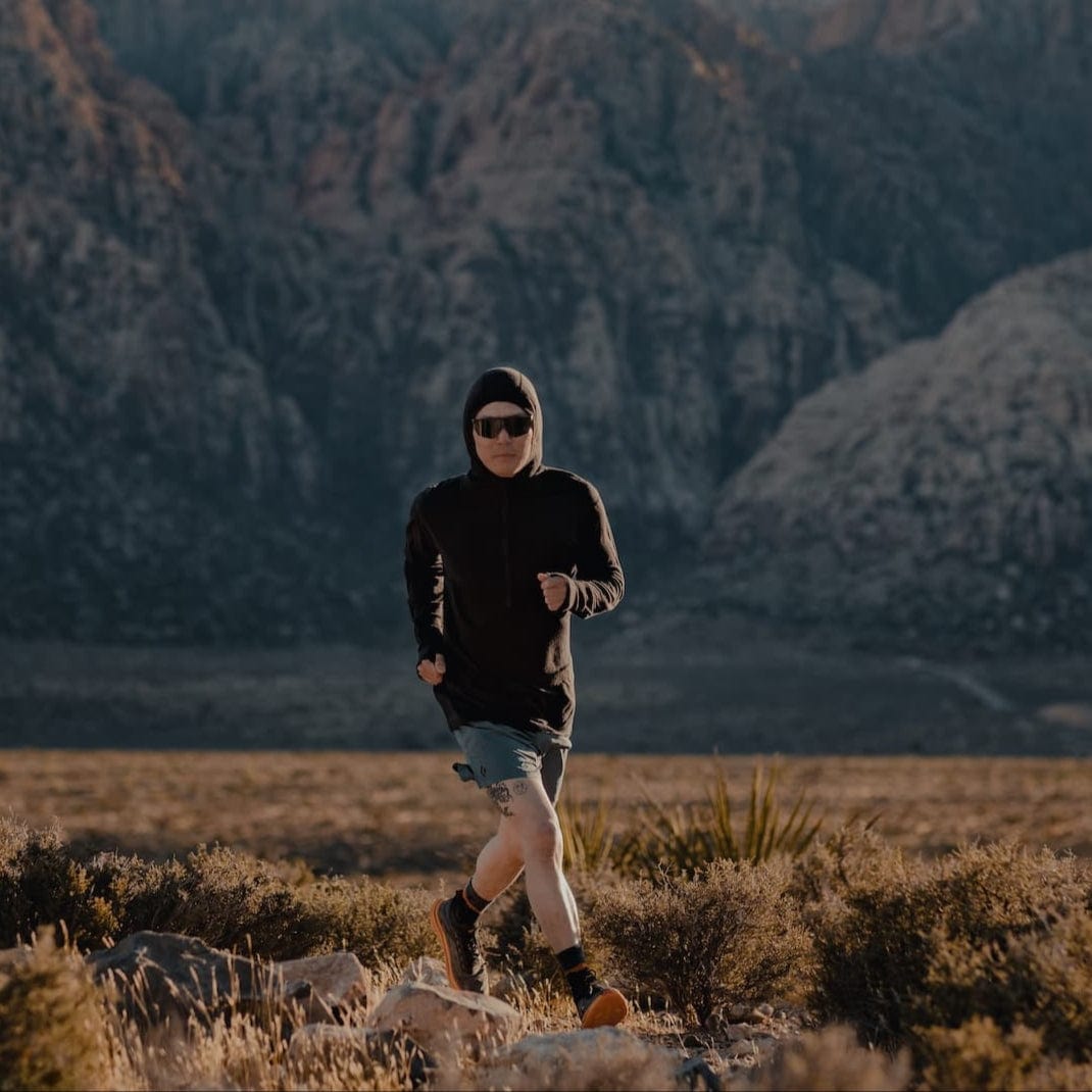 a man running in a black Pursuit Air Hoodie