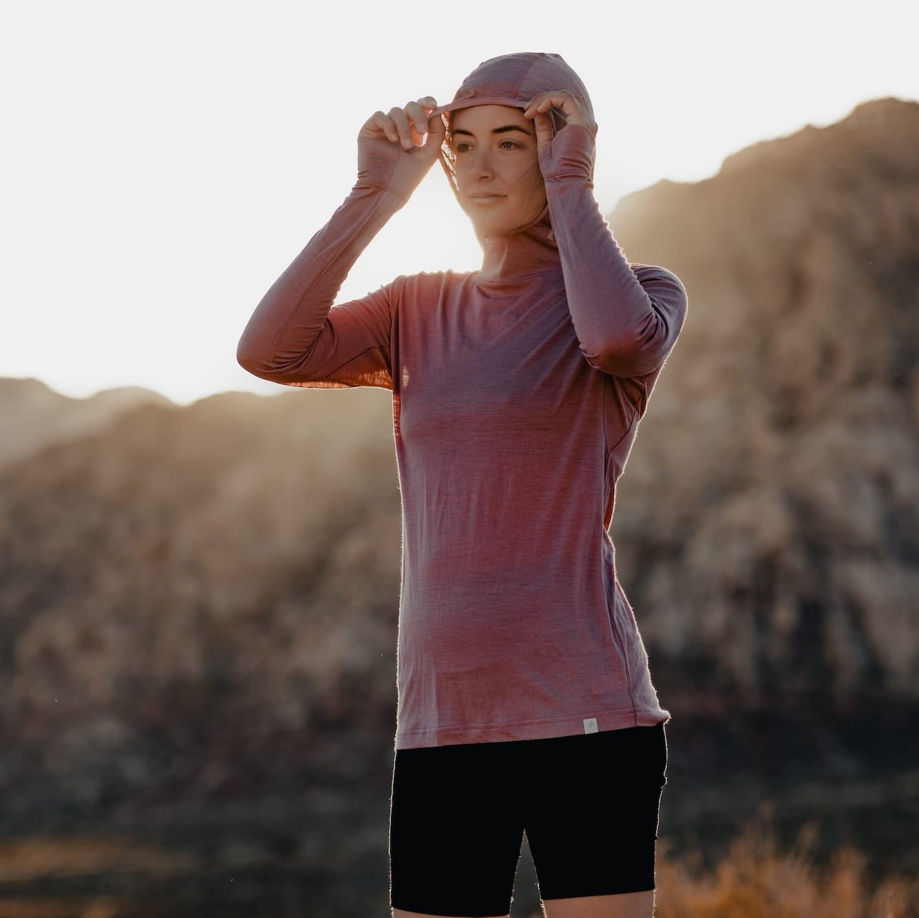 a woman wearing a Pursuit Ultralight Merino Hoodie