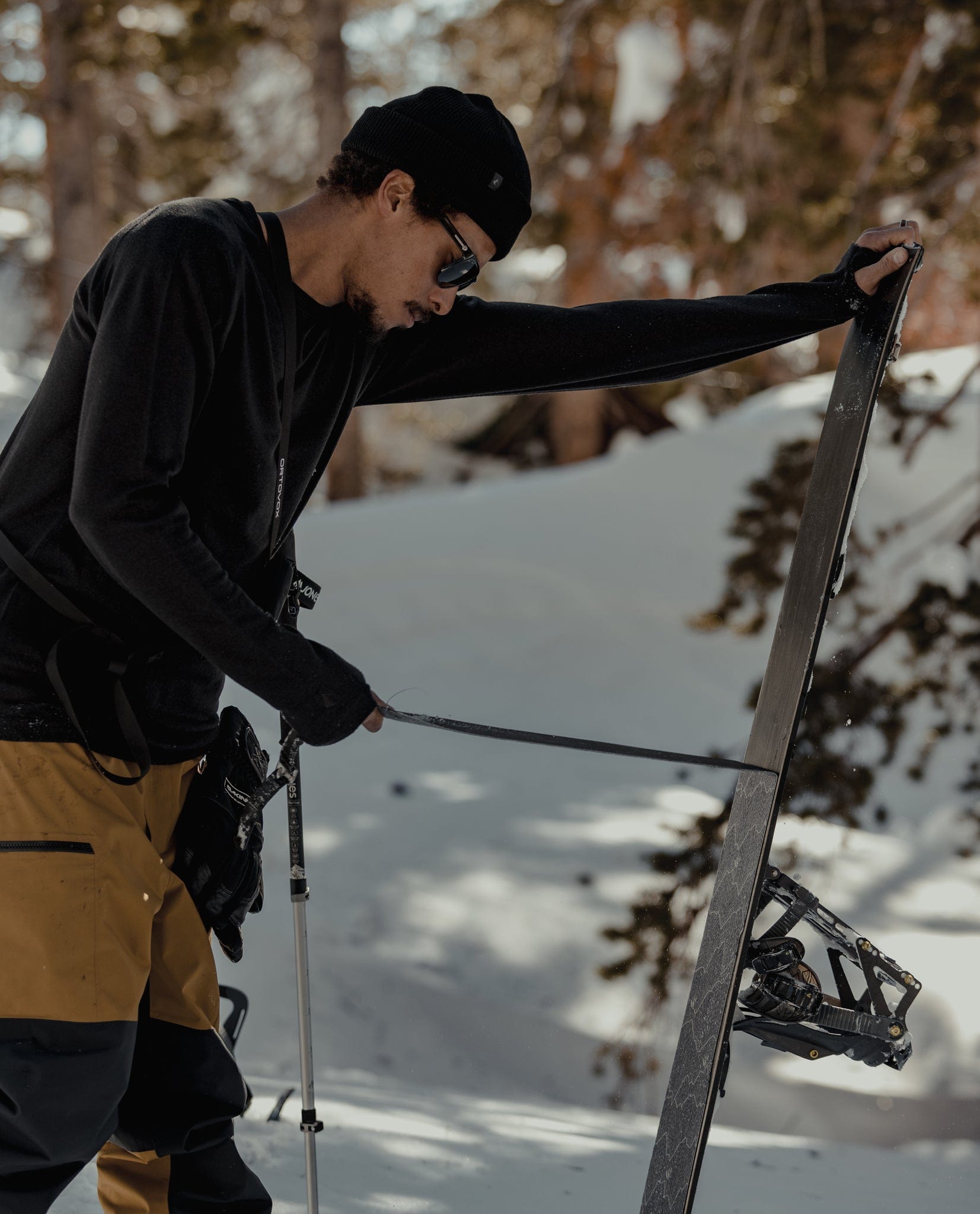 A man removes skins from his splitboard in the Mammoth Lakes backcountry