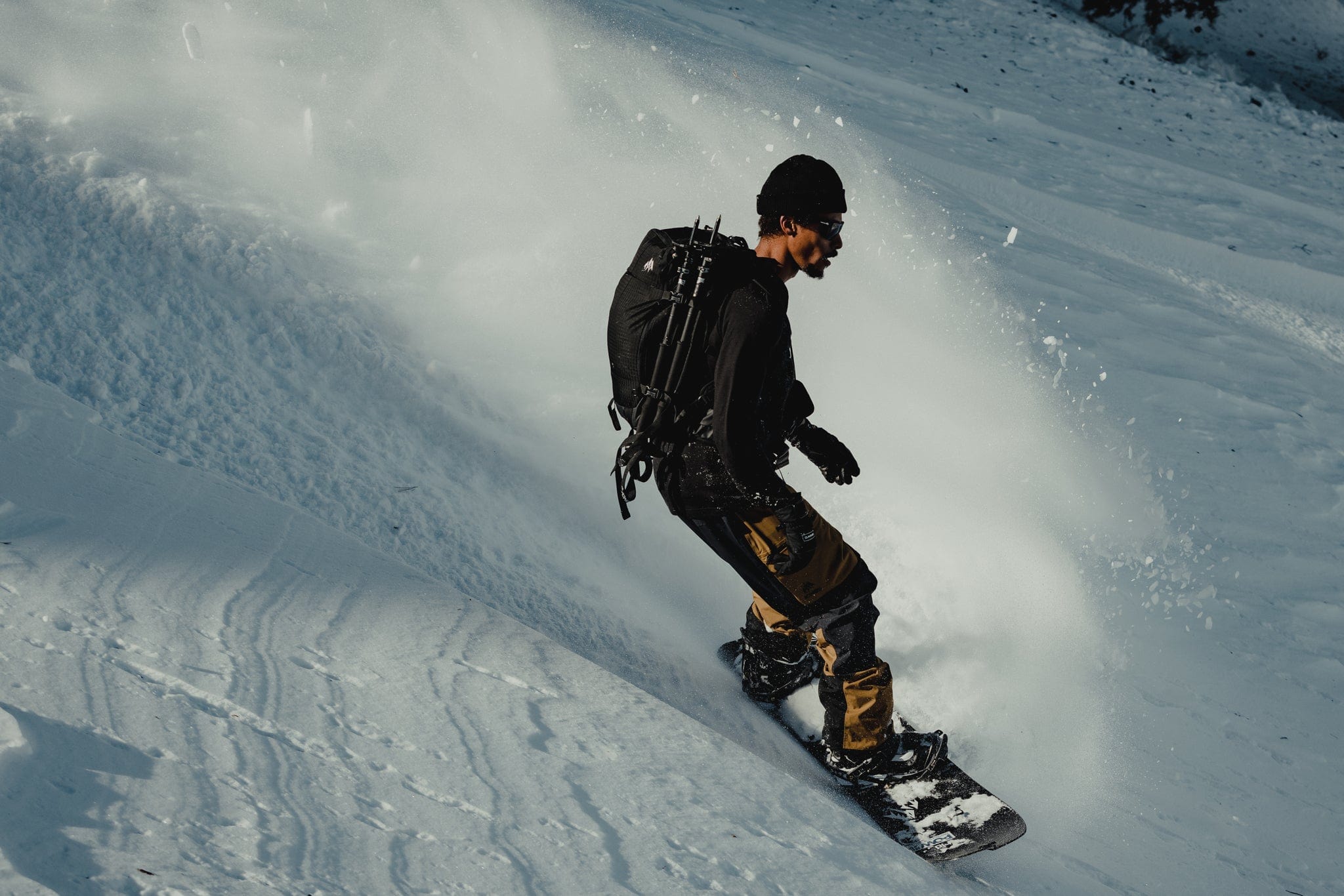a snowboarder descends a backcountry run in Ridge layers