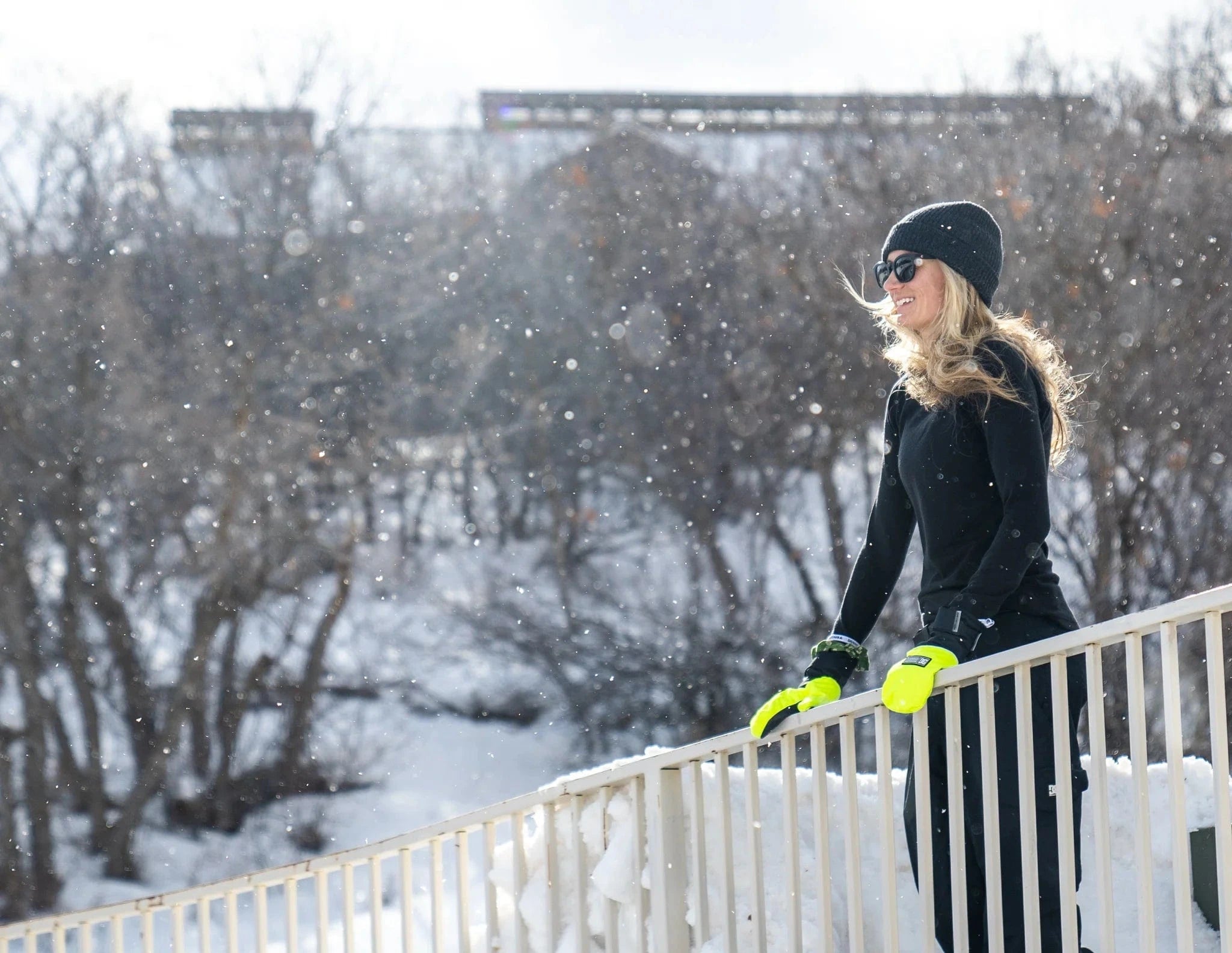 a woman stands on a balcony wearing Ridge Merino Inversion base layers