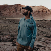 a man wearing a Solstice Merino Sun Hoodie