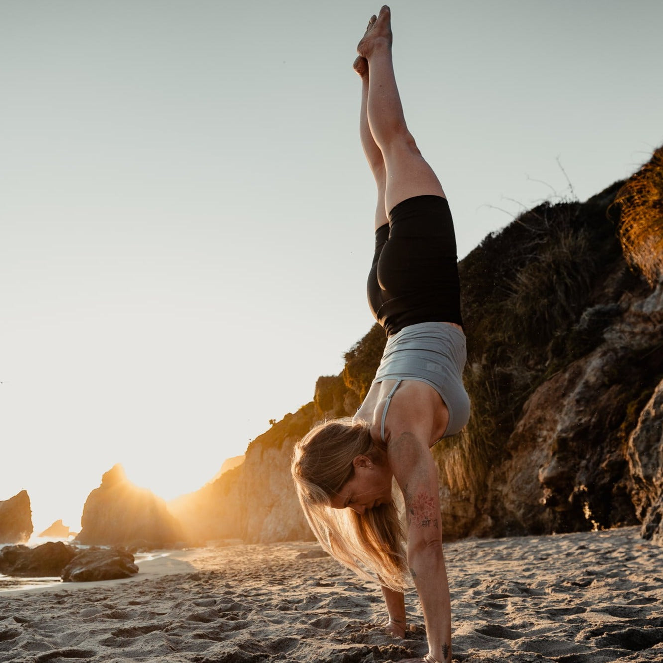 a woman does a handstand wearing Hilltop Bike Shorts and a Ridge bralette