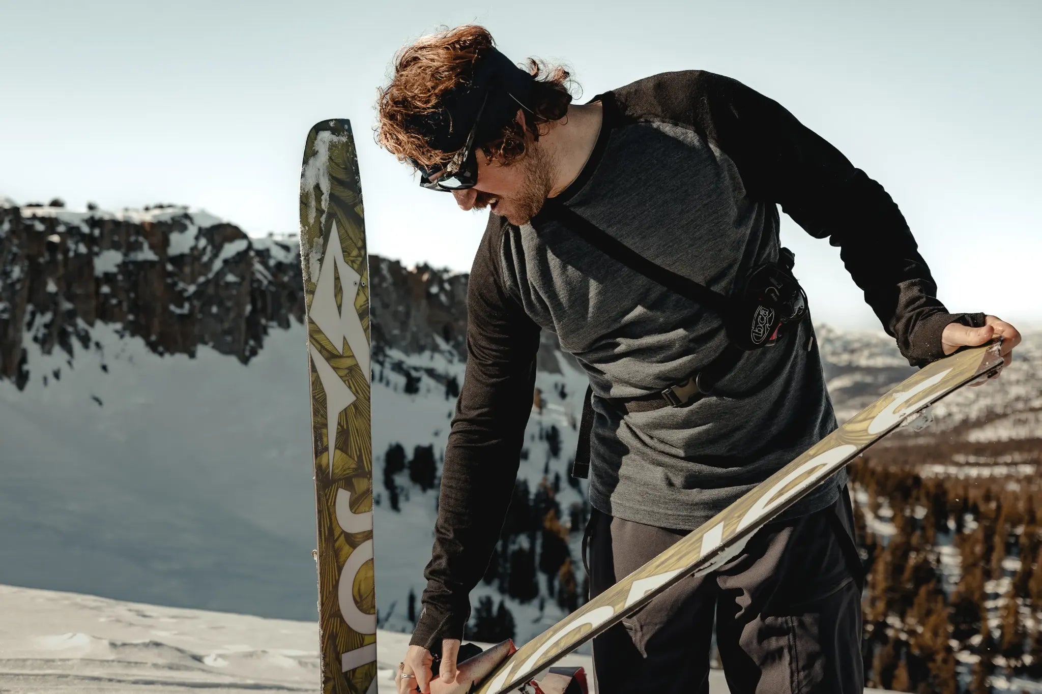 a splitboarder puts skins on his splitboard to prepare for the descent in the Mammoth Lakes backcountry