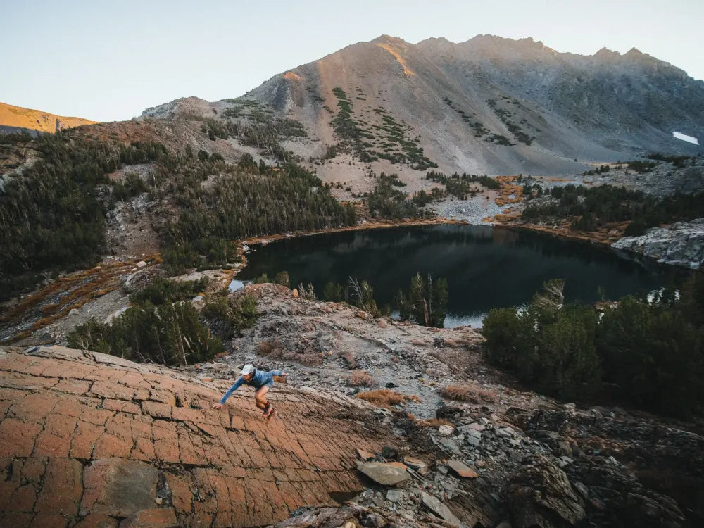 a runner scrambles up a low angle rock face in the Mammoth Lakes area