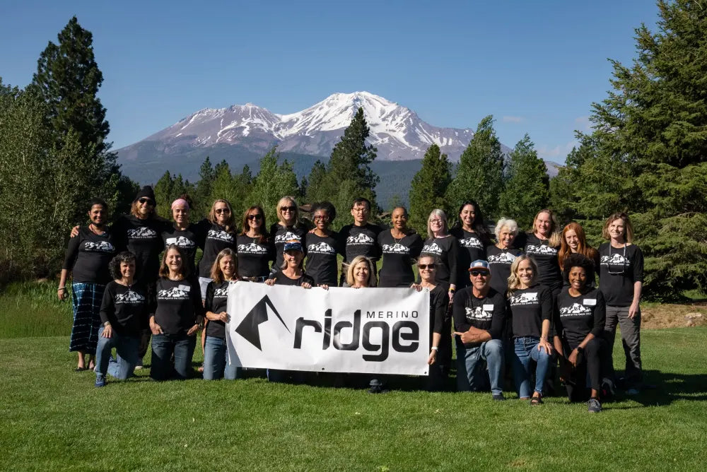 BCPP partners pose for a group photo with a Ridge Merino banner