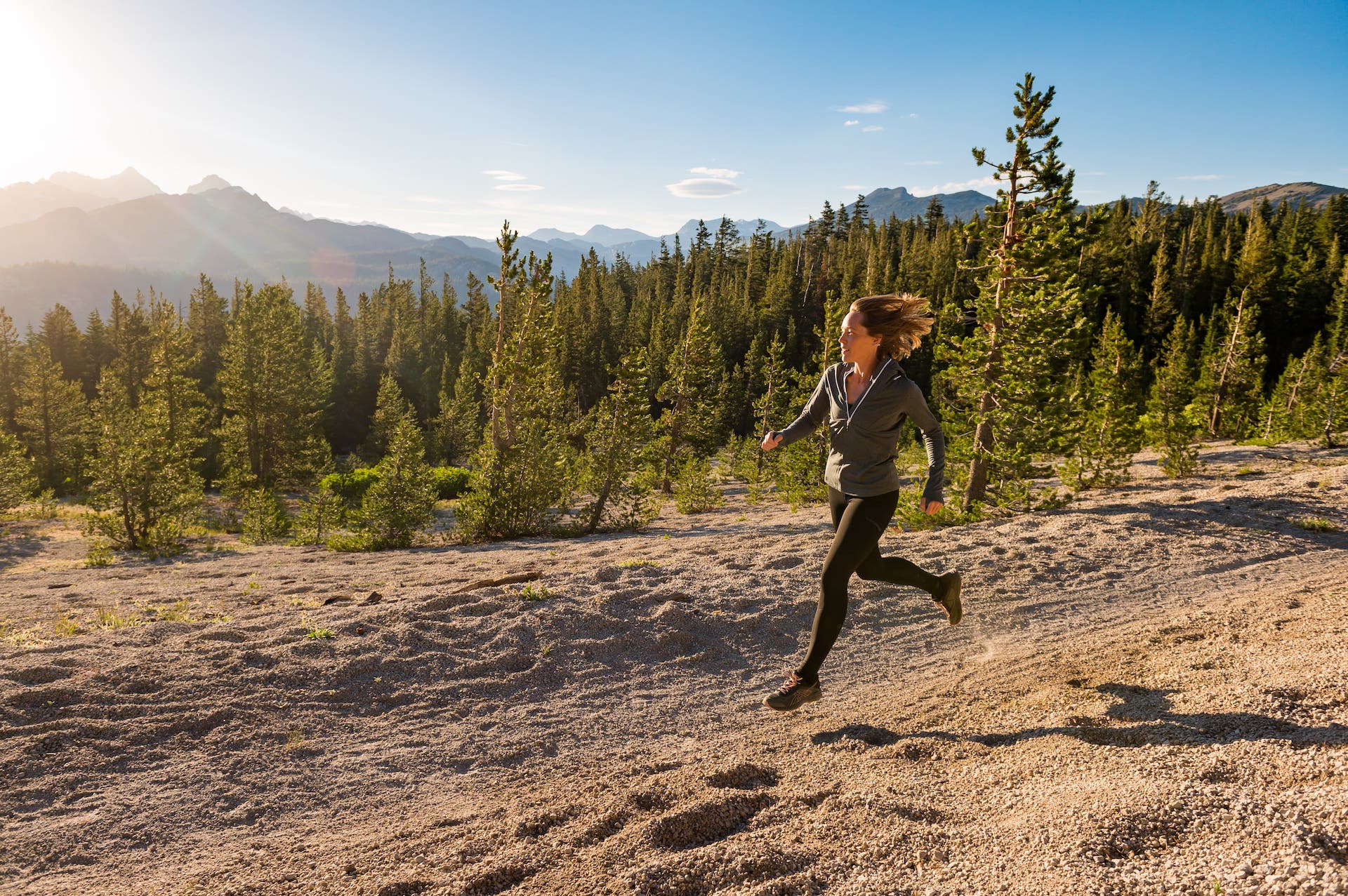a woman running down a hill in Ridge Merino Crowley Compression Merino Leggings