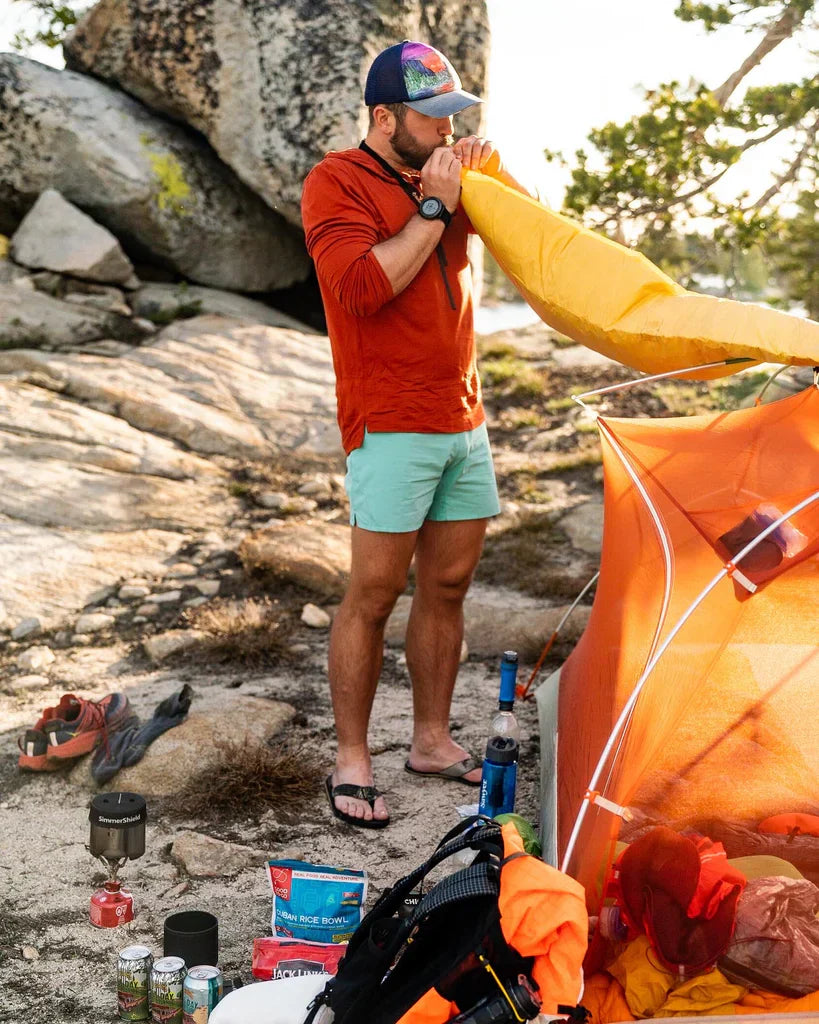Mac from Halfway Anywhere inflating his sleeping pad wearing a Solstice Sun Hoodie