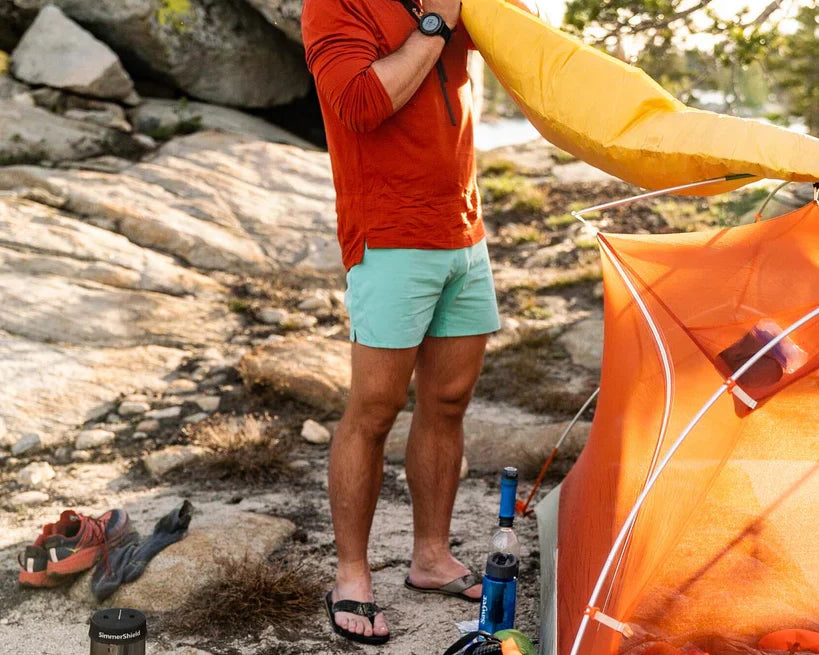 Mac from Halfway Anywhere inflating his sleeping pad wearing a Solstice Sun Hoodie