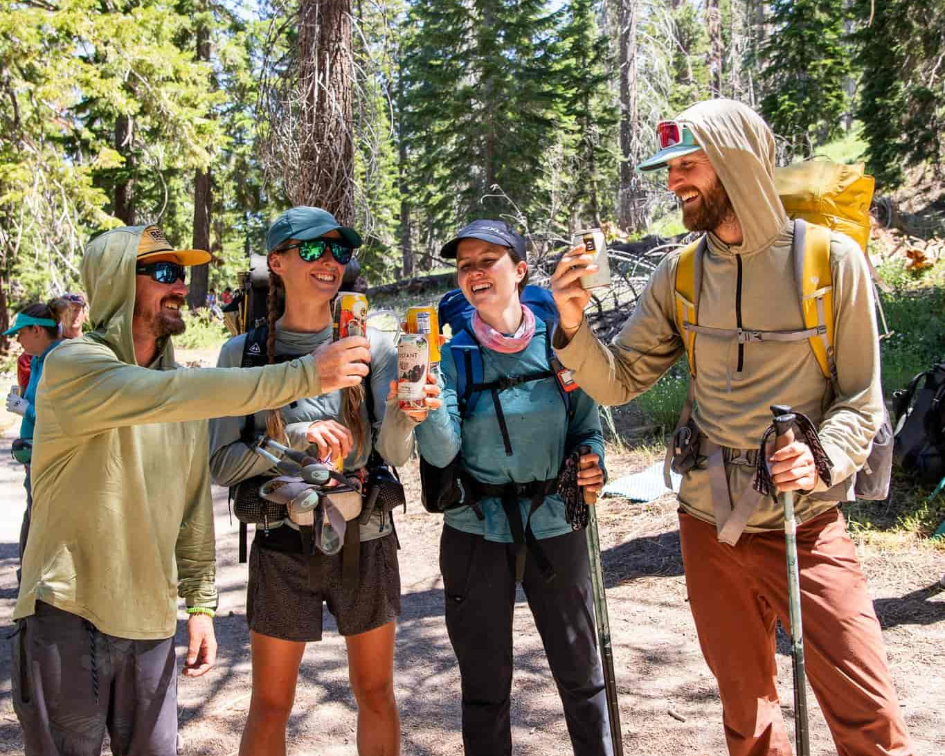 four PCT hikers, some of which are wearing Solstice Sun Hoodies, cheers before heading back to the trail
