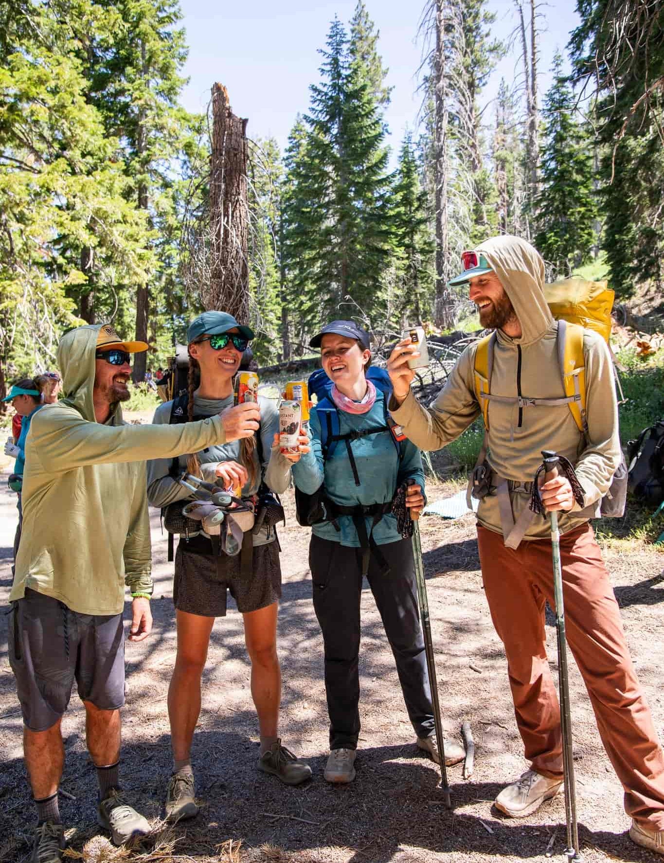 four PCT hikers, some of which are wearing Solstice Sun Hoodies, cheers before heading back to the trail