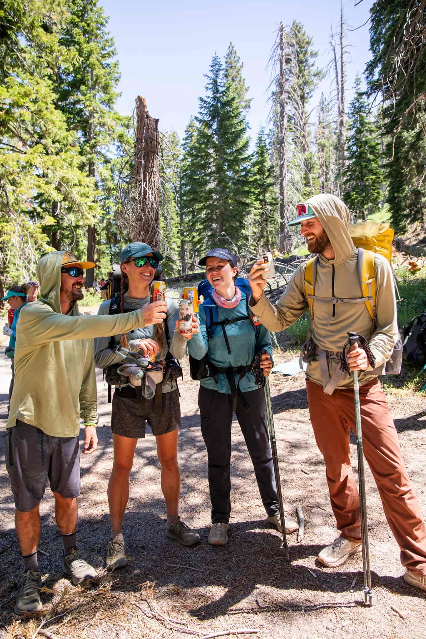 four PCT hikers, some of which are wearing Solstice Sun Hoodies, cheers before heading back to the trail