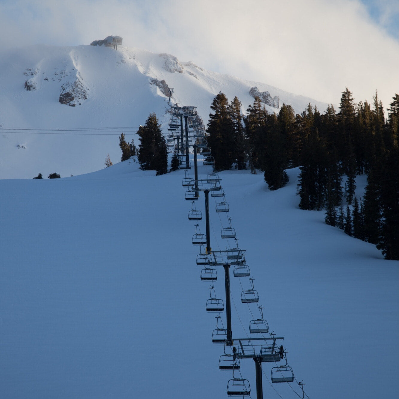 a chairlift going up Mammoth Mountain on a snowy day