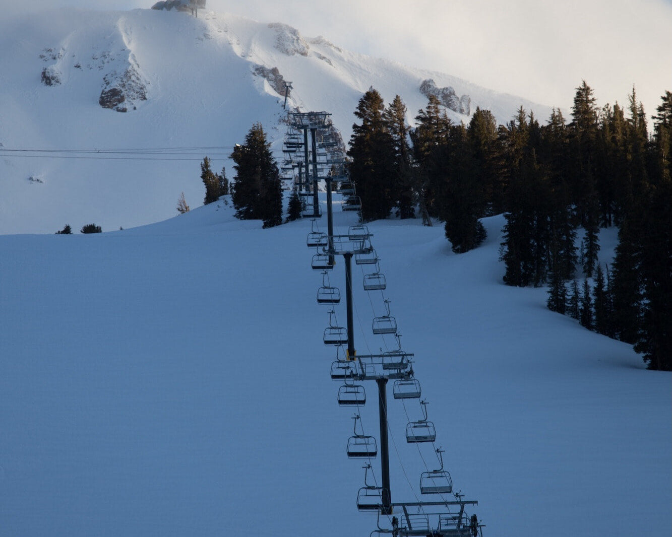 a chairlift going up Mammoth Mountain on a snowy day