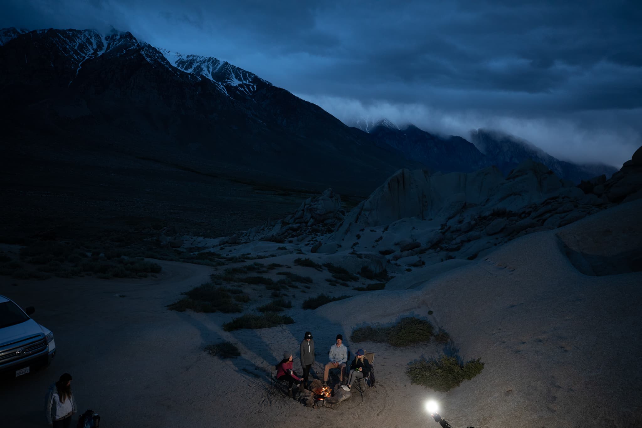 a group of friends hanging out by a campfire in the Bishop, CA area