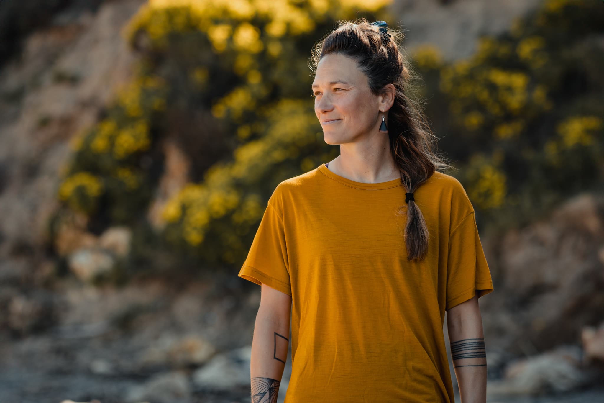 a woman wearing a yellow Natural Relaxed Fit Tee at the beach