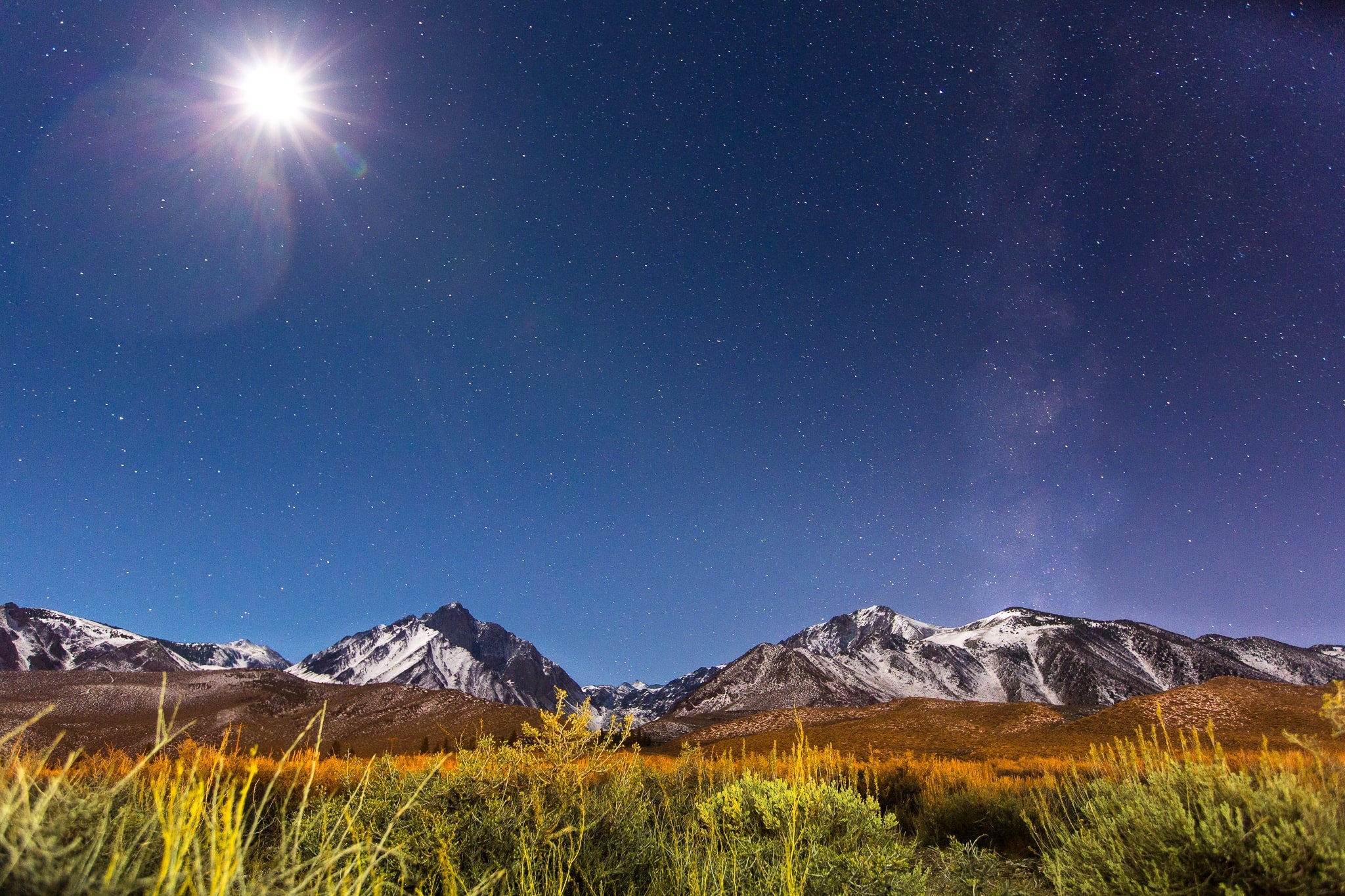 the mountains around Mammoth Lakes at night with the moon and stars out