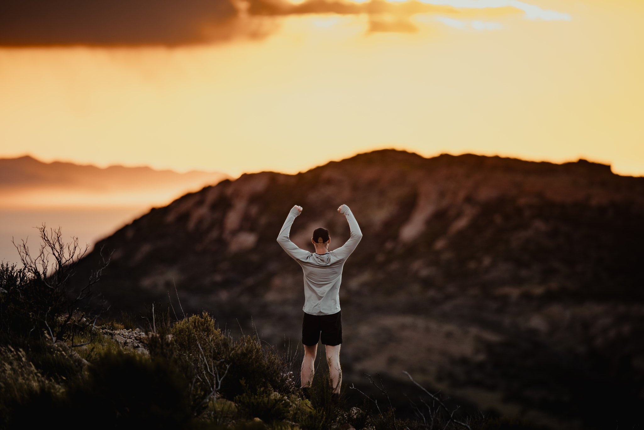 a man strikes a strong pose after a trail run in the mountains of Malibu, CA