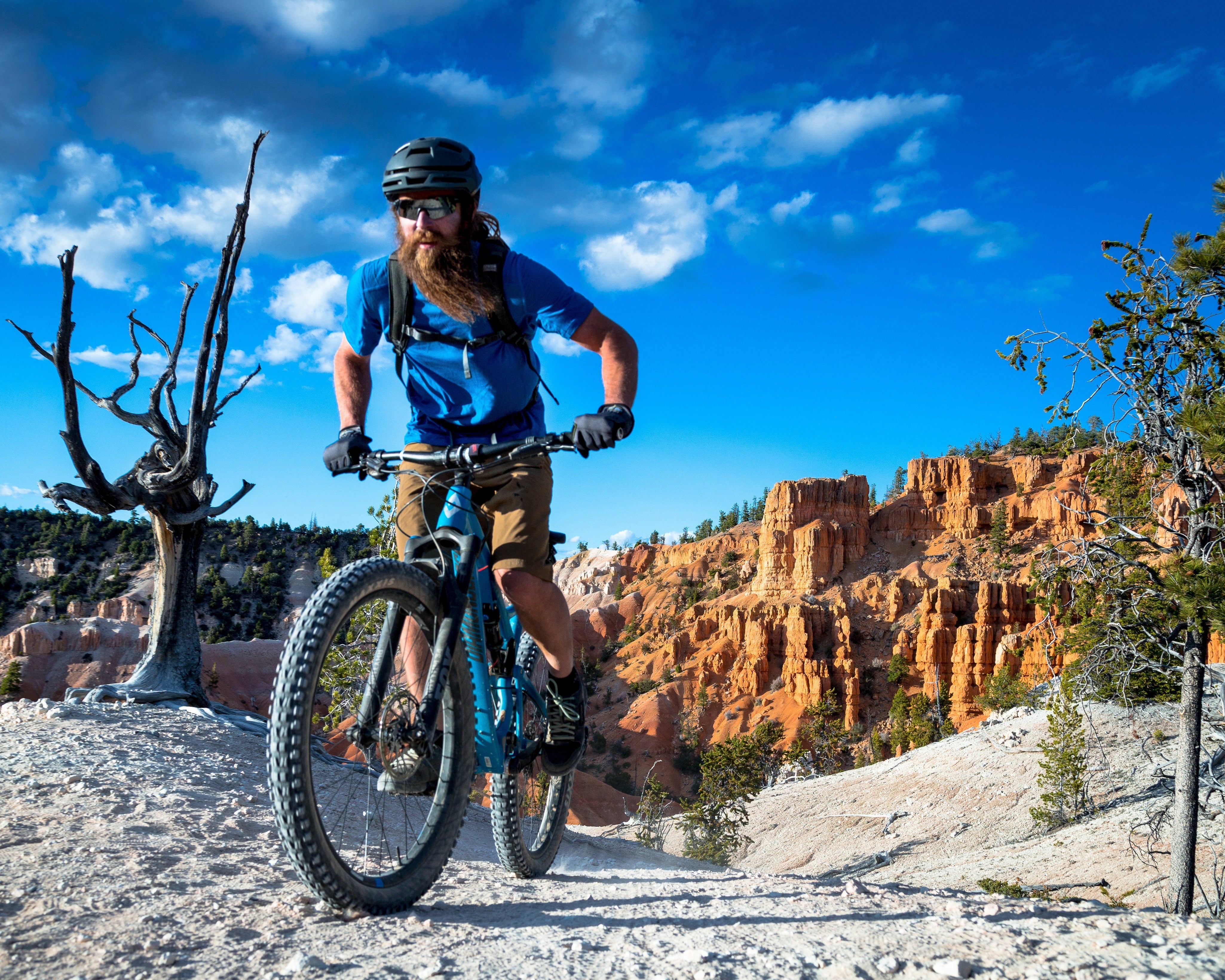 a man mountain biking in the desert wearing Ridge layers