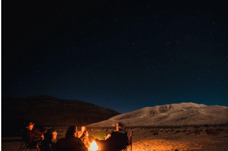 friends enjoying a campfire at night in the desert