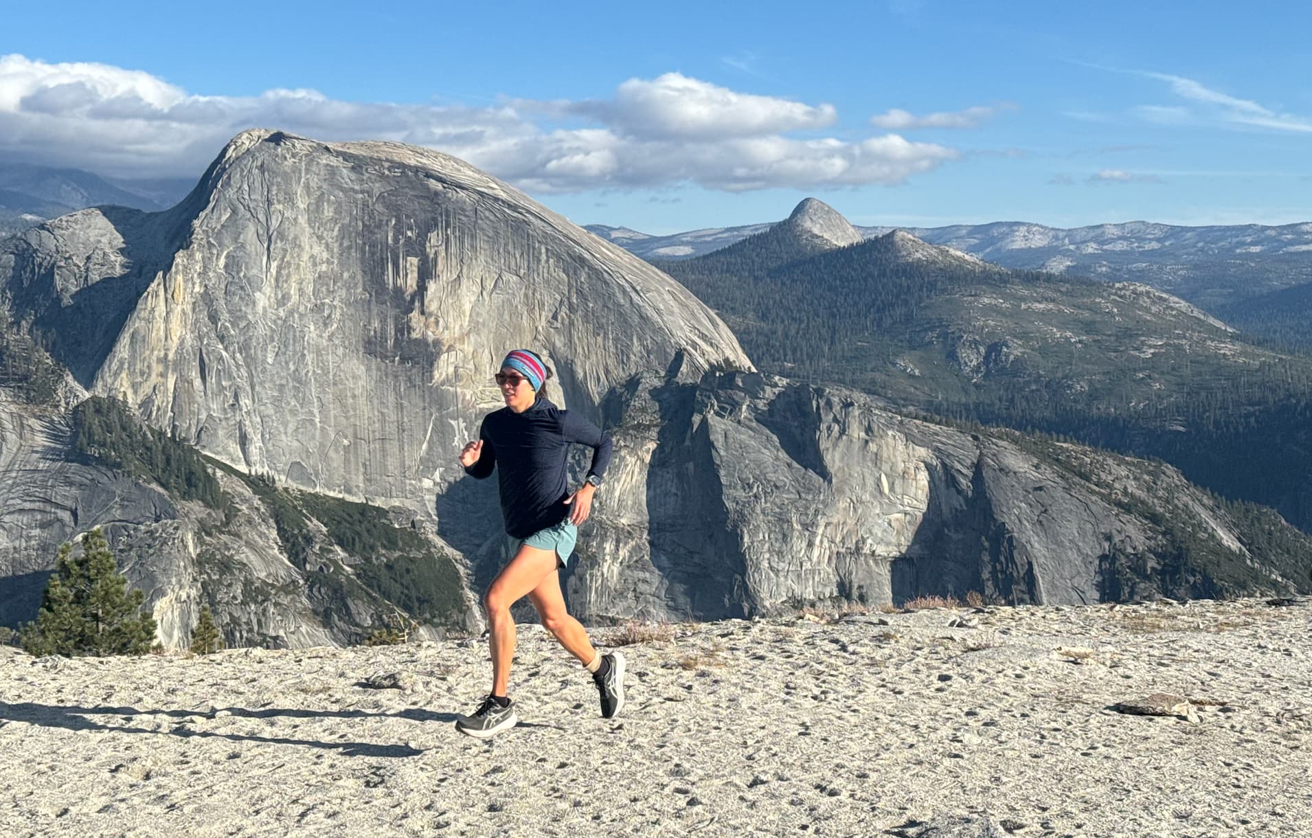 Jenica Law running in a Pursuit Hoodie with Half Dome in the background