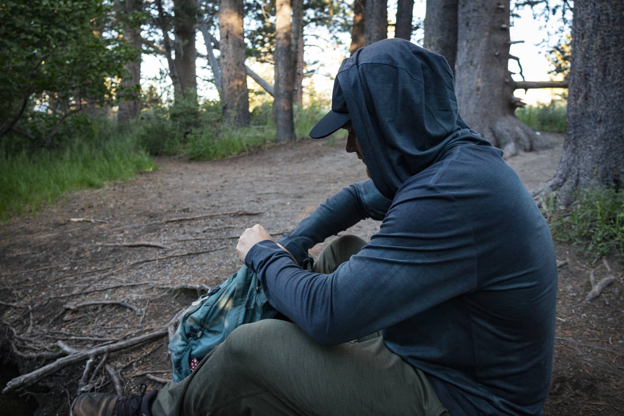 a hiker wearing a Solstice Sun Hoodie taking a break
