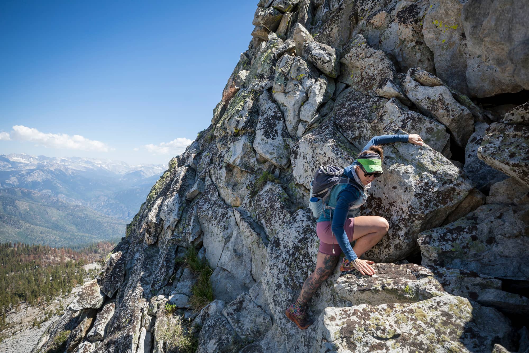 Lindsey Jackson scrambling on a peak in the Sierra wearing a Pursuit Hoodie