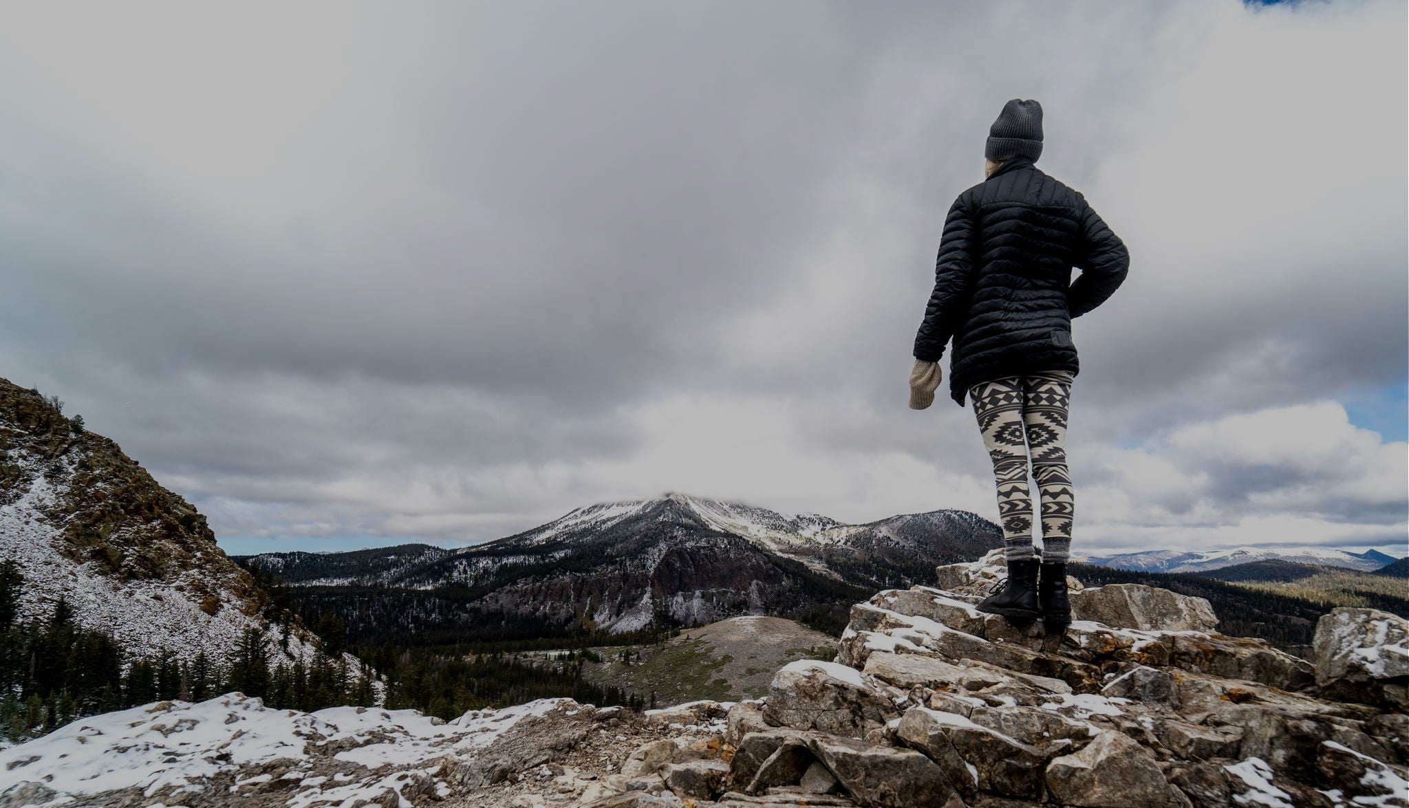 a woman wearing Ridge Merino leggings looking out over the mountains