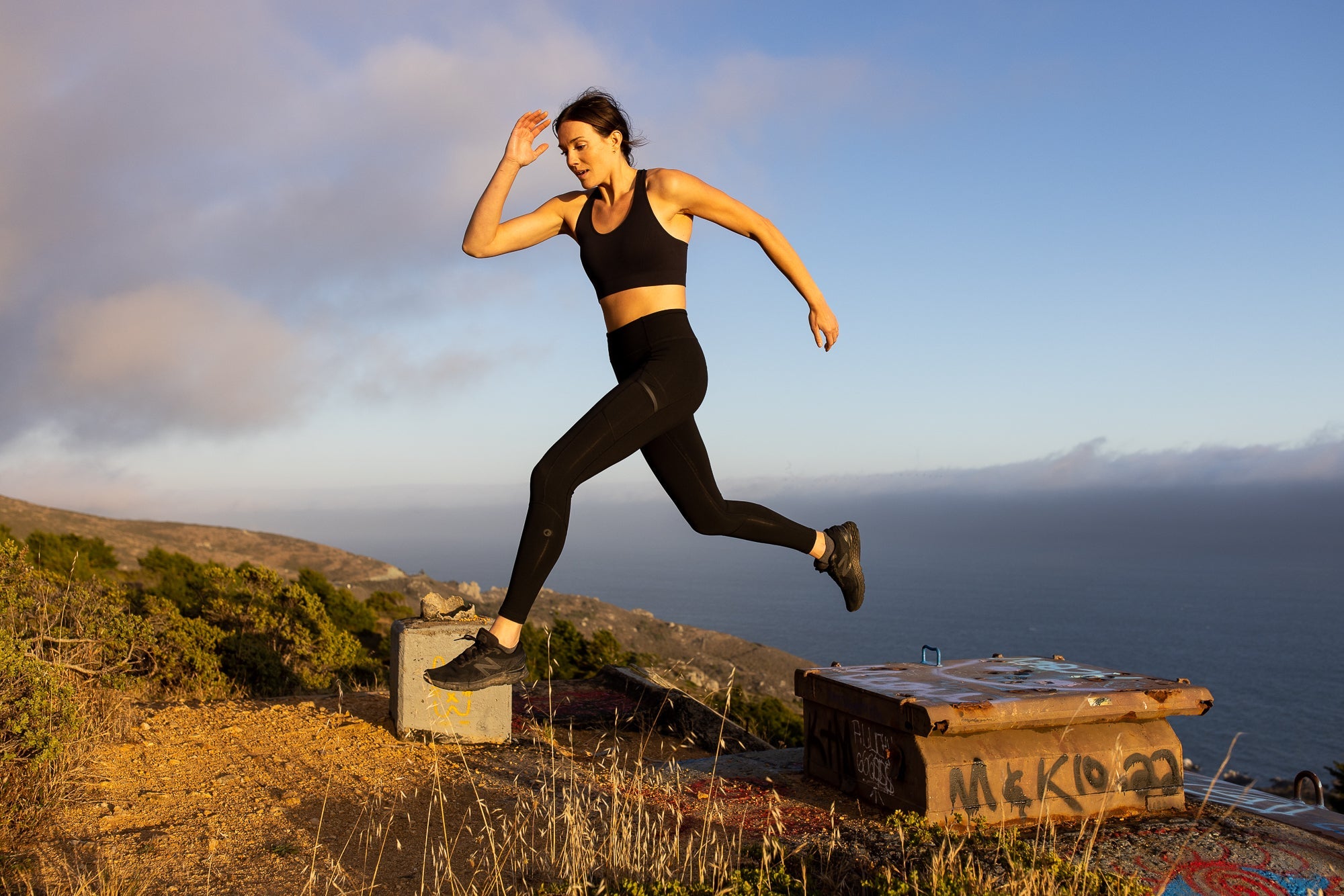 a woman jumping in the Bay Area wearing Crowley Compression Tights and Ridge Merino's Seamless Send-It Sports Bra