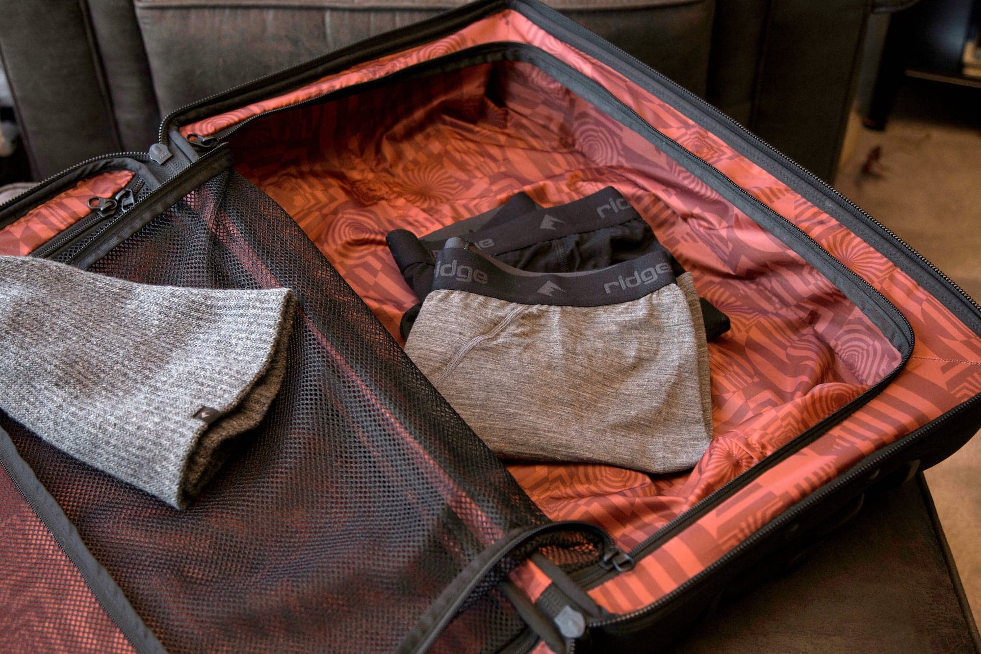 a suitcase with Ridge Merino Boxer Briefs and a Ridge beanie in it