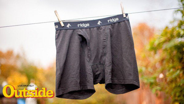 a pair of Ridge Merino boxer briefs hanging on a line to dry with the Outside Magazine logo beside it
