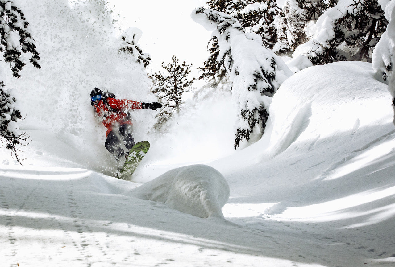 a snowboarder cruising through fresh powder