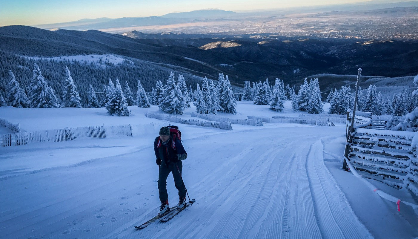 a skier sinning uphill in moody winter light