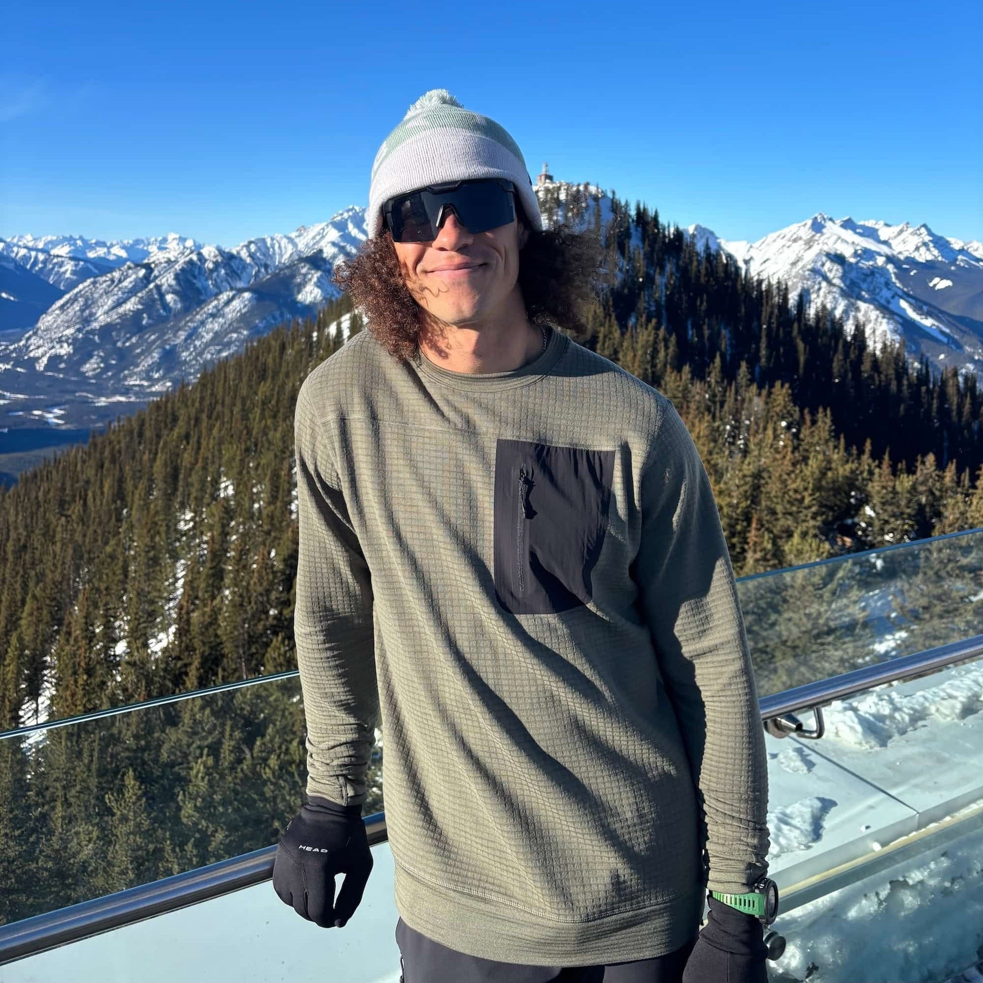 a skier wearing a Cloudripper Grid Fleece Pullover with a beanie and sunglasses