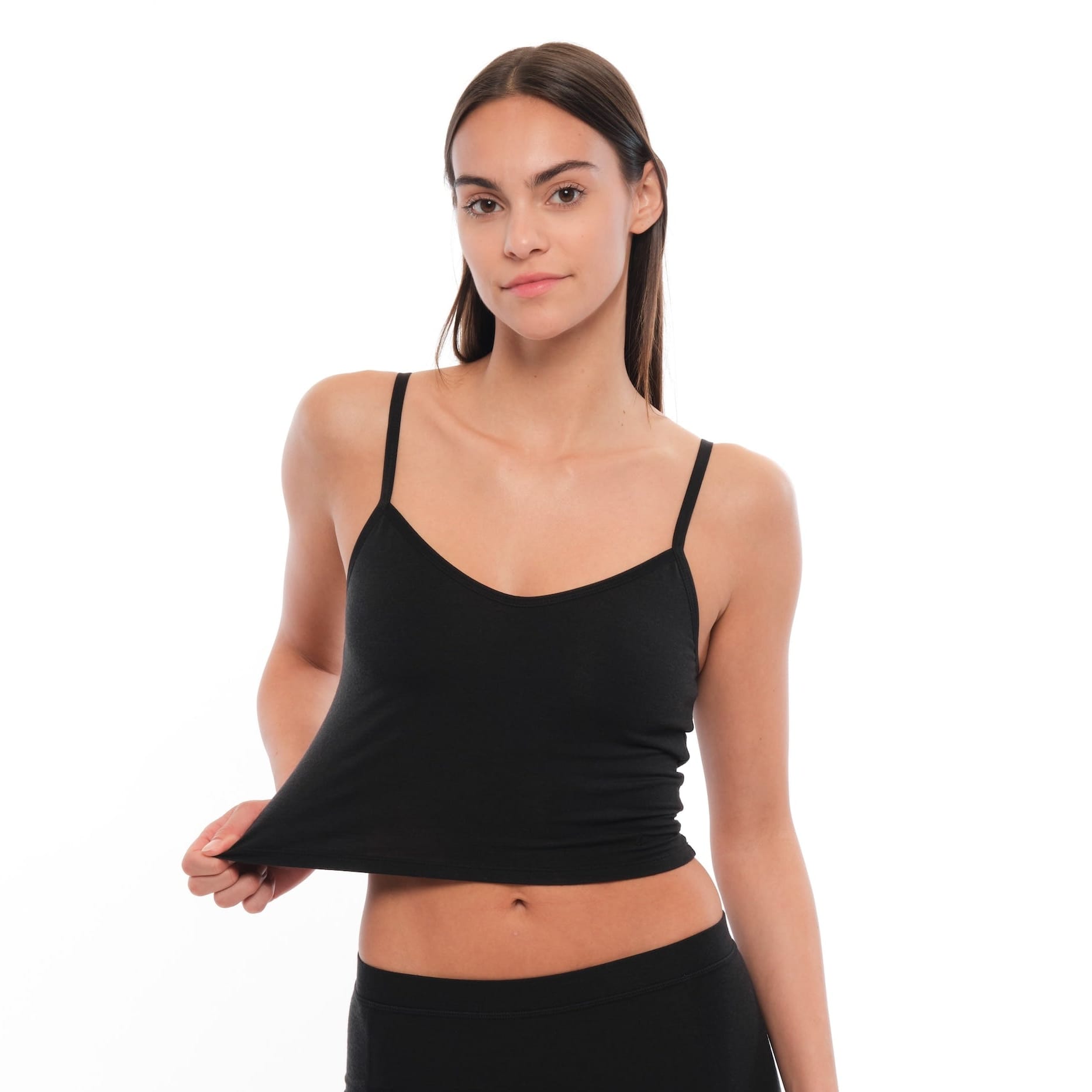a woman showing the stretch of a black Merino wool bralette with matching boy shorts