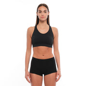 a woman wearing a Ridge Merino wool sports bra with matching black Merino boy shorts