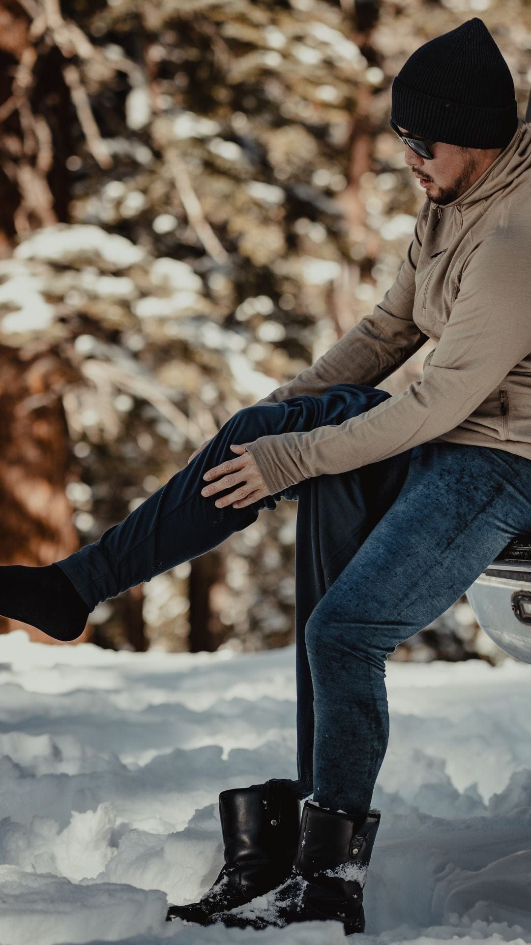 a man puts on Aspect base layers before going for a snowboard tour