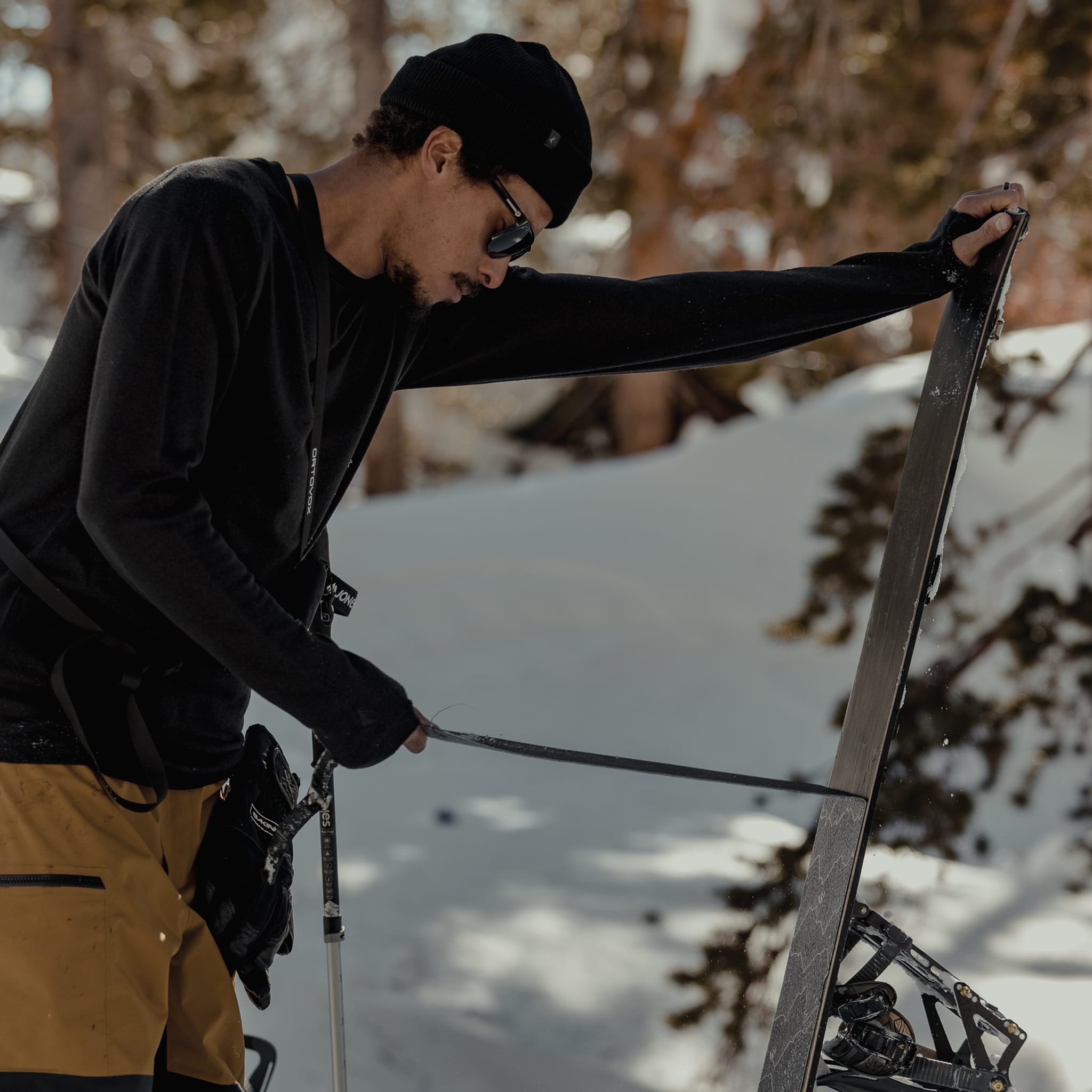 a man removes the skins from his splitboard wearing Inversion base layers