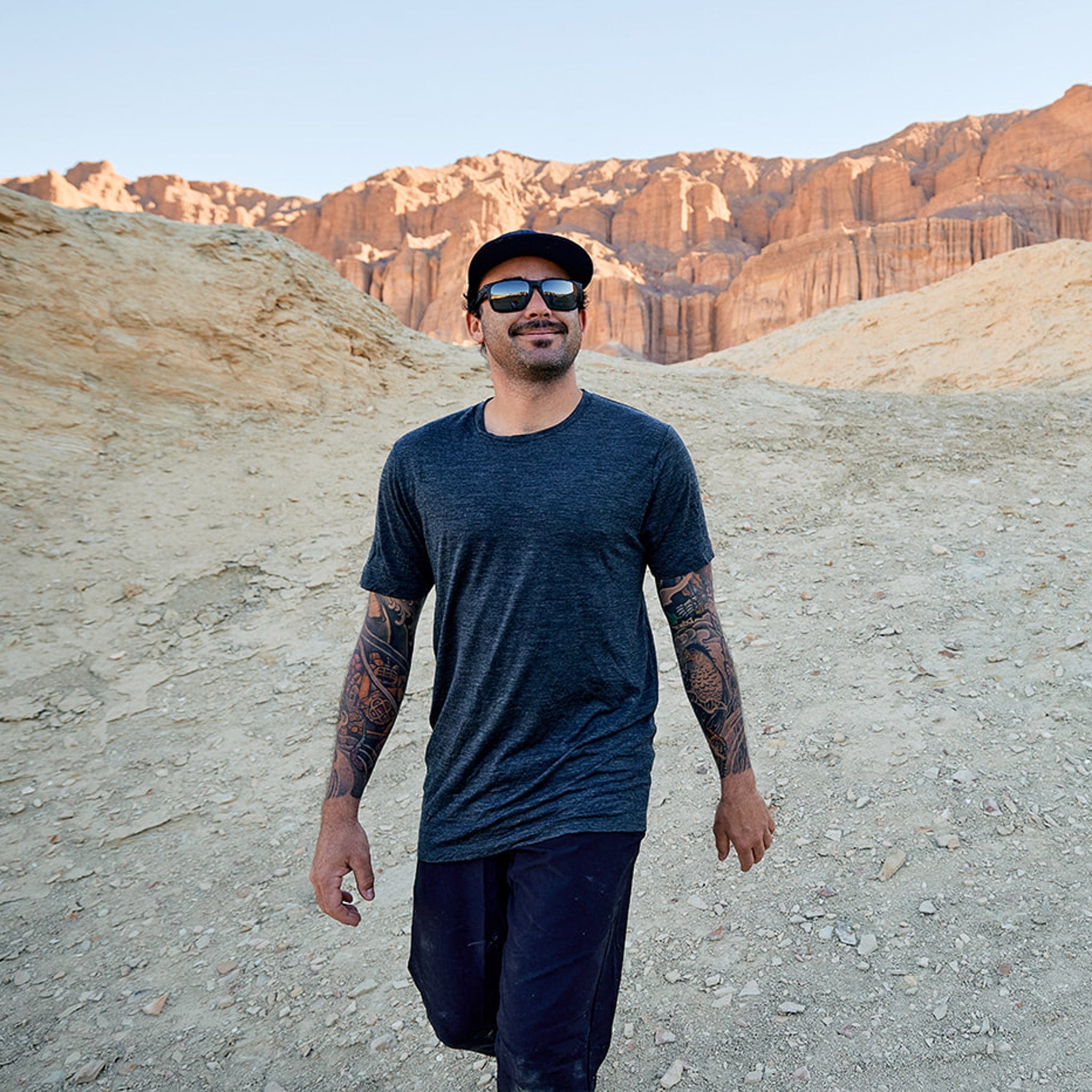 A man on a hike in Death Valley wearing a Ridge Natural Tee