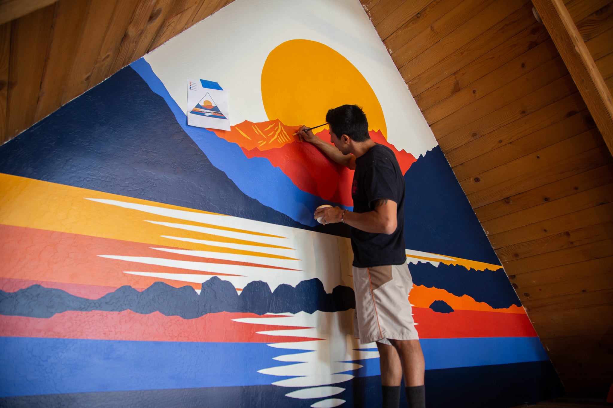 Artist Nate Riefke (@saltytimbers) paints a Convict Lake mural inside the Ridge Collective showroom