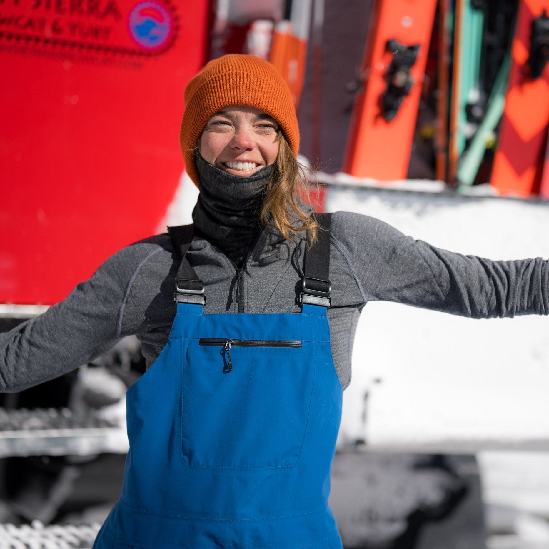 a skier layers up wearing a Convict Hoodie and Layton Beanie and ski bibs